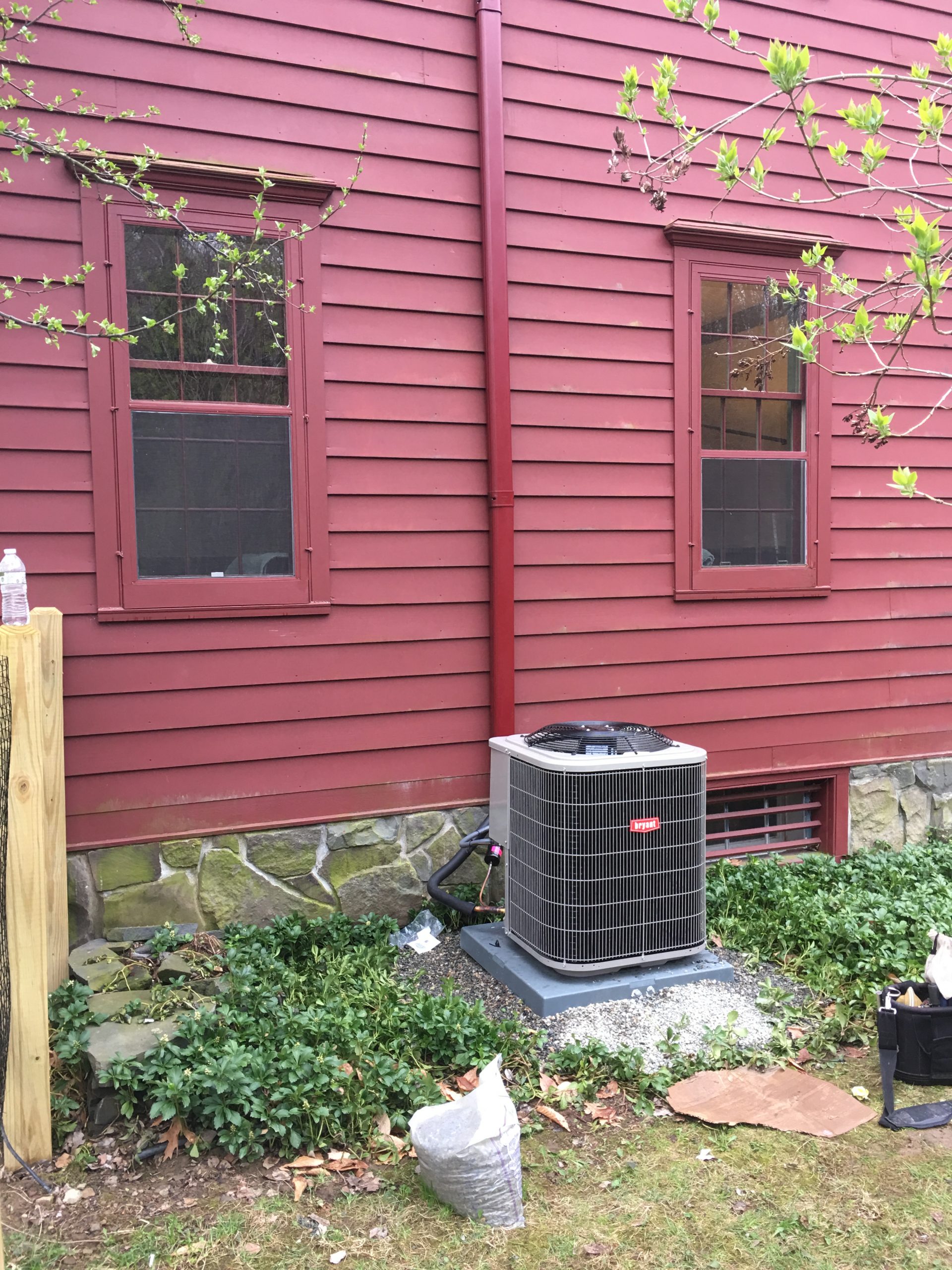 Lennox central AC unit, newly installed on the side of a red house
