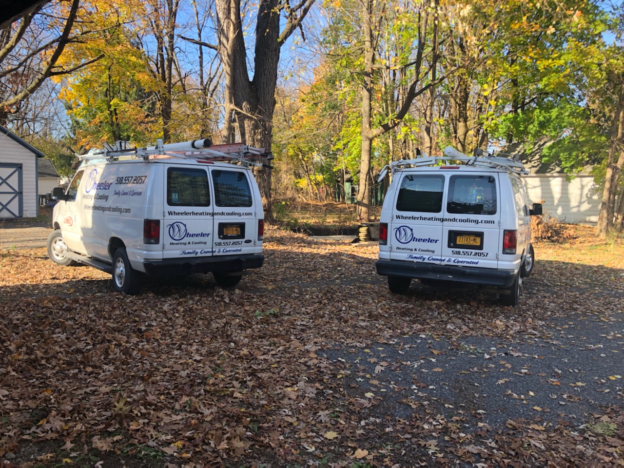 Photo of Wheeler Heating & Cooling's 2 vans, parked side-by-side in a driveway