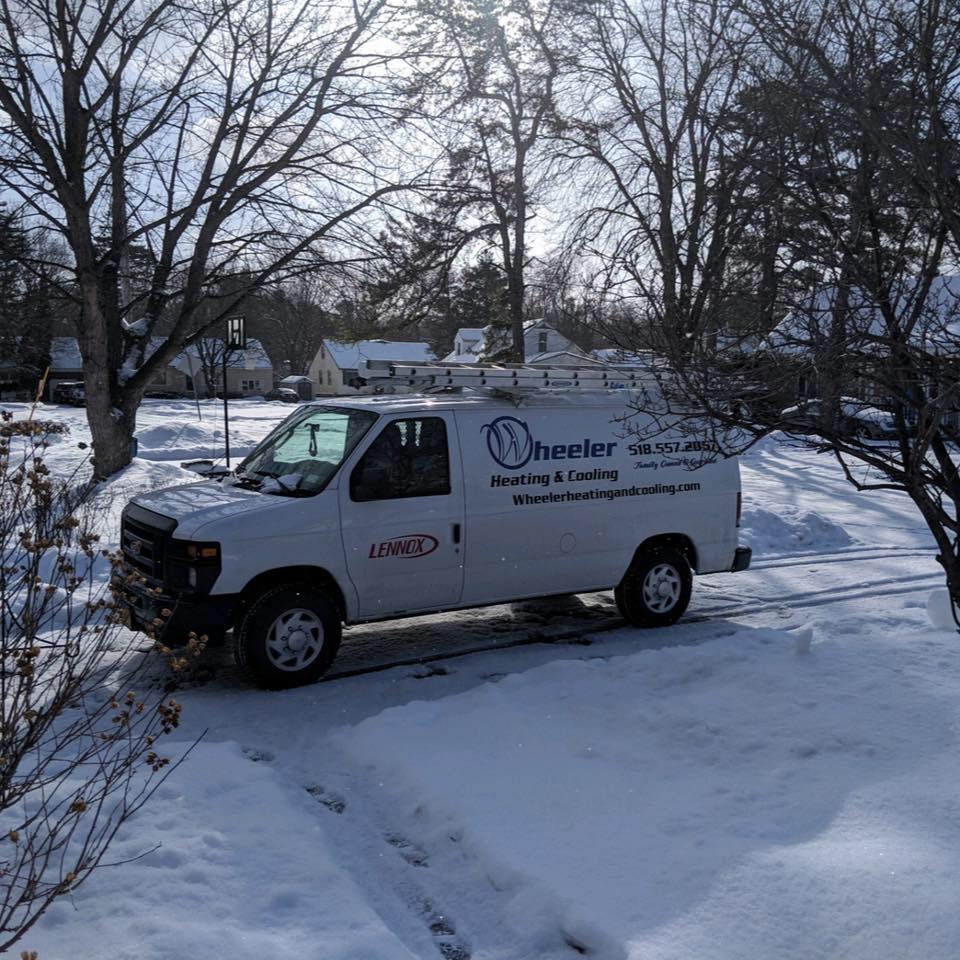 Wheeler Heating & Cooling van parked in snowy driveway